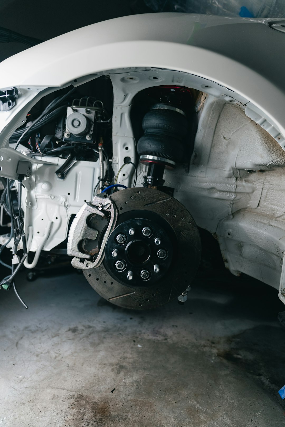 white-cars-disassembled-front-suspension-and-wheel-assembly-vjviwkq-klu